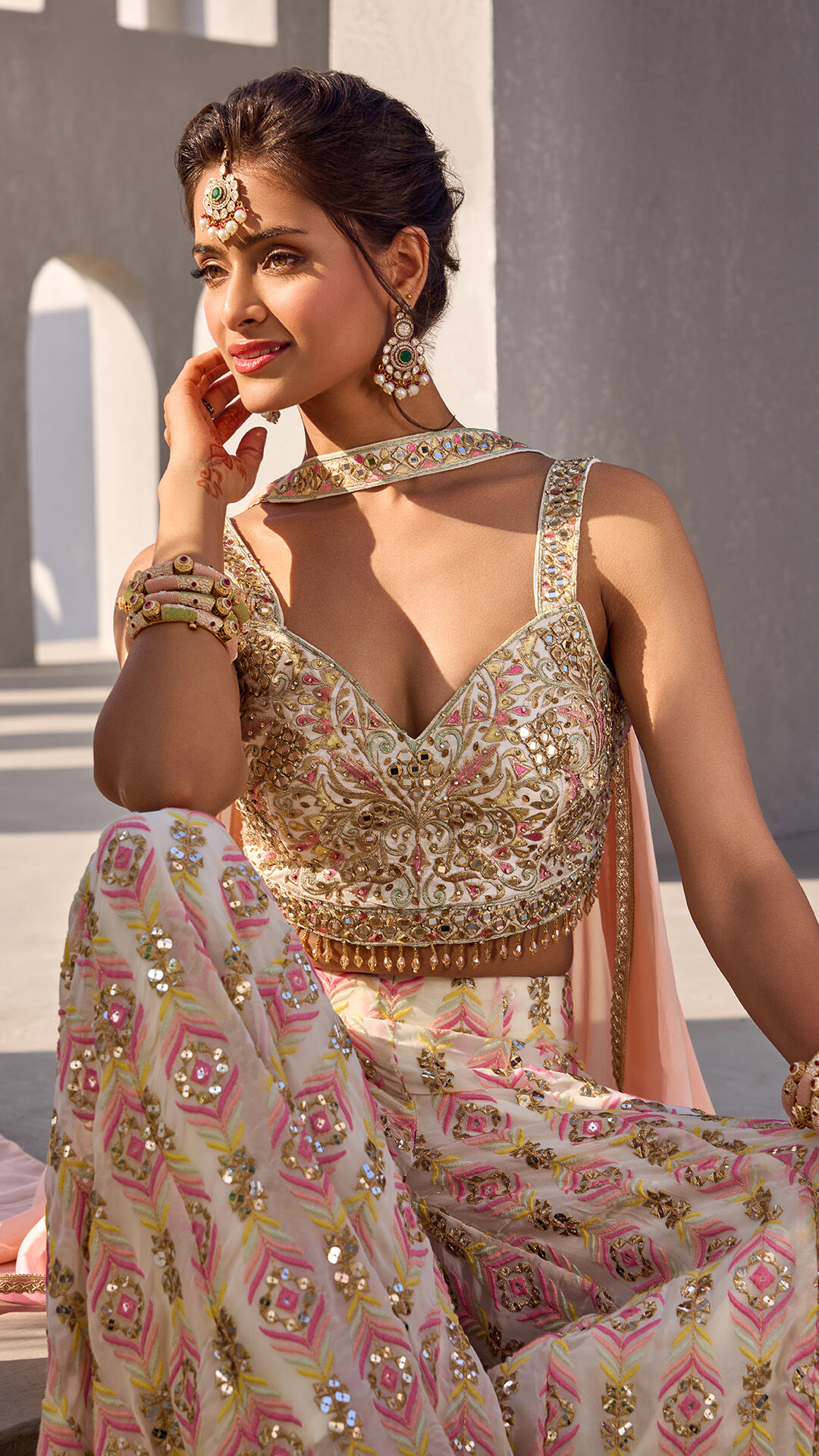 Woman wearing a printed white Indian dress with colorful bangles and a traditional bindi
